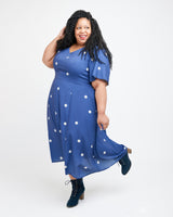 Woman wearing a blue dress with white polka dots on a white background. This dress is the Upton Dress & Skirt sewing pattern from Cashmerette.