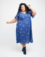 Woman wearing a blue dress with white polka dots on a white background. This dress is the Upton Dress & Skirt sewing pattern from Cashmerette.