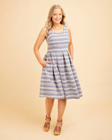 Woman wearing a blue and white striped dress on a beige background. This dress is the Upton Dress & Skirt sewing pattern from Cashmerette.