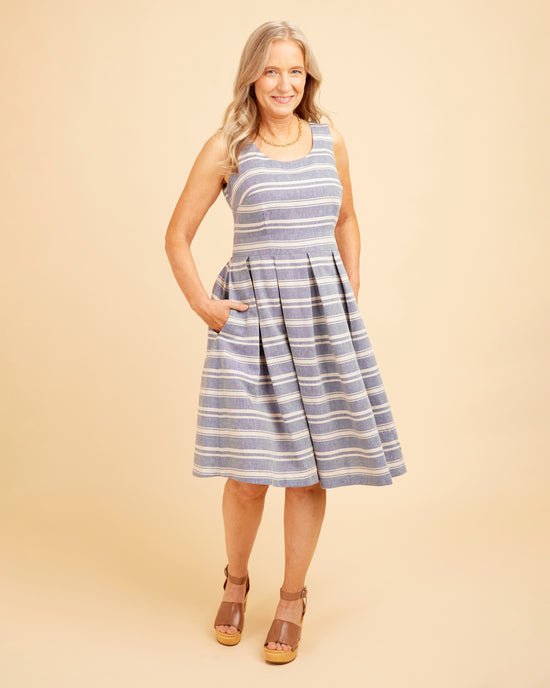 Woman wearing a blue and white striped dress on a beige background. This dress is the Upton Dress & Skirt sewing pattern from Cashmerette.