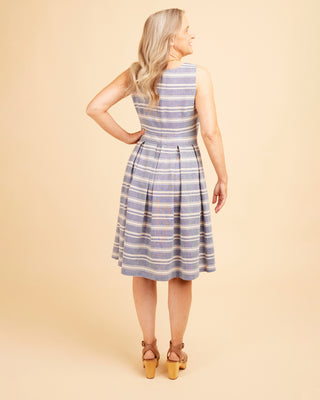 Woman wearing a blue and white striped dress against a beige background. This dress is the Upton Dress & Skirt sewing pattern from Cashmerette.