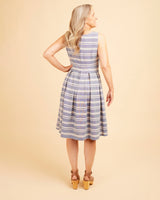 Woman wearing a blue and white striped dress against a beige background. This dress is the Upton Dress & Skirt sewing pattern from Cashmerette.
