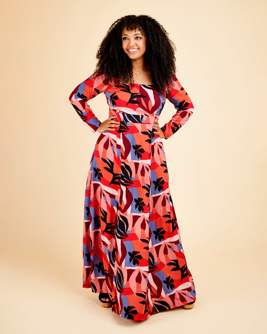Woman wearing a colorful patterned dress on a beige background. This dress is the Upton Dress & Skirt sewing pattern from Cashmerette.