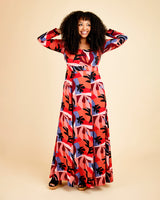Woman wearing a colorful patterned dress on a beige background. This dress is the Upton Dress & Skirt sewing pattern from Cashmerette.