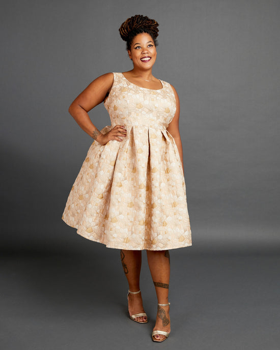 Woman wearing a beige floral dress against a gray background. This dress is the Upton Dress & Skirt sewing pattern from Cashmerette.
