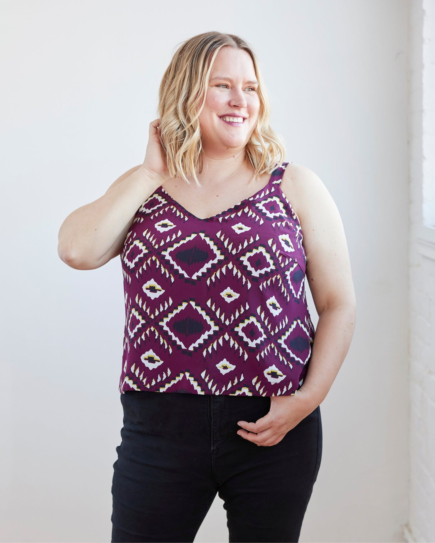 Woman wearing a purple patterned tank top against a white background. This is the Avola Dress & Top sewing pattern from Cashmerette.