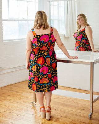Woman wearing a colorful dress standing in front of a mirror. This dress is the Hampden Dress sewing pattern from Cashmerette.