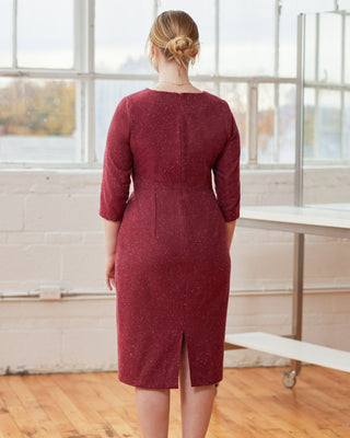 Woman wearing a burgundy dress standing in a room with large windows. This dress is the Wyman Dress Sloper sewing pattern from Cashmerette.