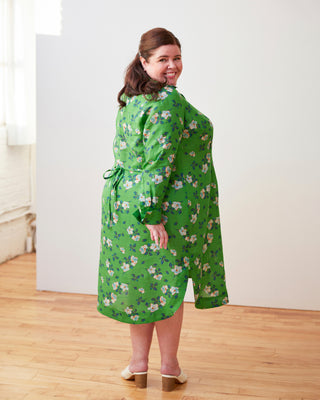Woman wearing a green floral dress standing in a room with wooden floor and white walls. This dress is the Winvale Dress & Tunic sewing pattern from Cashmerette.