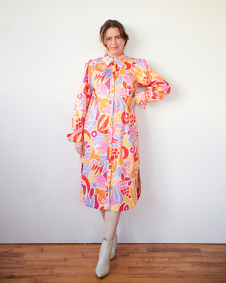 Woman wearing a colorful floral dress against a white wall. This dress is the Winvale Dress & Tunic sewing pattern from Cashmerette.