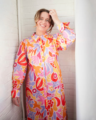 Person wearing a colorful floral dress against a white wall. This dress is the Winvale Dress & Tunic sewing pattern from Cashmerette.