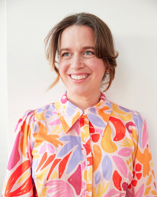 Person wearing a colorful floral blouse against a plain background. This dress is the Winvale Dress & Tunic sewing pattern from Cashmerette.