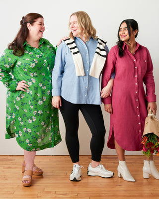 Three women standing together, each wearing a different dress with a plain background. This dress is the Winvale Dress & Tunic sewing pattern from Cashmerette.