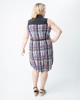 Woman wearing a plaid dress with a black top on a white background. This dress is the Harrison Shirtdress sewing pattern from Cashmerette.