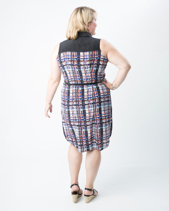 Woman wearing a plaid dress with a black top on a white background. This dress is the Harrison Shirtdress sewing pattern from Cashmerette.