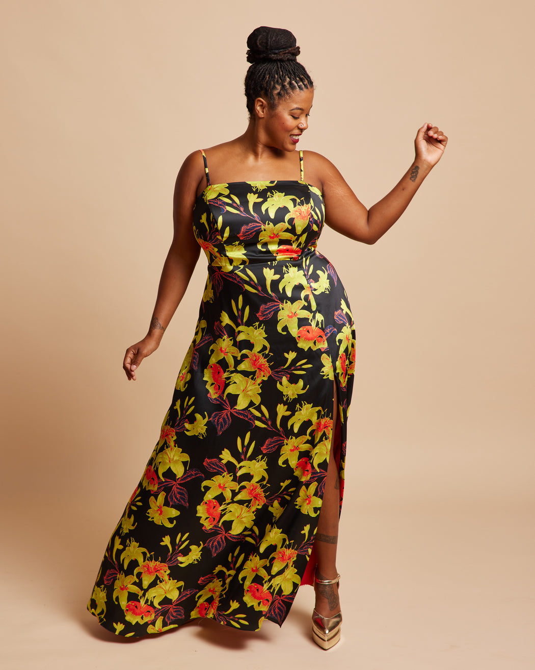 Woman wearing a floral dress on a beige background. This dress is the Ellington Strapless Dress sewing pattern from Cashmerette.