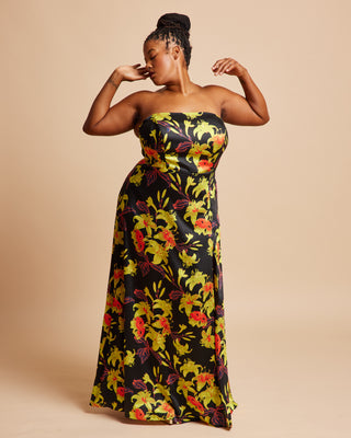 Woman wearing a strapless floral dress on a beige background. This dress is the Ellington Strapless Dress sewing pattern from Cashmerette.