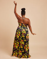 Woman wearing a strapless floral dress with a beige background. This dress is the Ellington Strapless Dress sewing pattern from Cashmerette.
