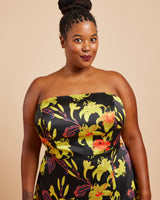 Woman wearing a strapless dress with a floral pattern on a beige background. This dress is the Ellington Strapless Dress sewing pattern from Cashmerette.