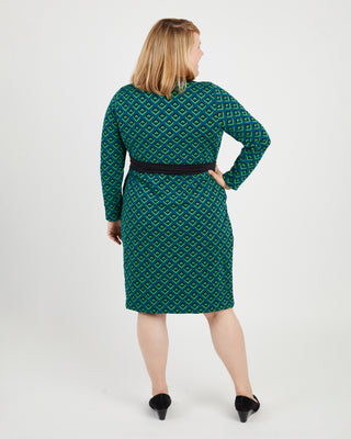 Woman wearing a green patterned dress on a white background. This dress is the Appleton Wrap Dress sewing pattern from Cashmerette.