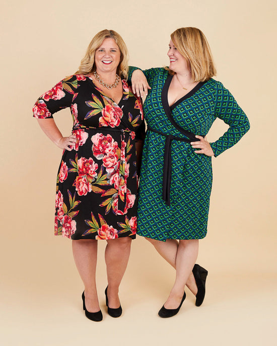 Two women wearing floral and patterned dresses on a beige background. This dress is the Appleton Wrap Dress sewing pattern from Cashmerette.