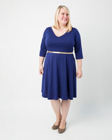 Woman wearing a blue dress with a white background. This dress is the Turner Dress sewing pattern from Cashmerette.