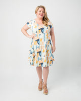 Woman wearing a patterned dress on a white background. This dress is the Turner Dress sewing pattern from Cashmerette.