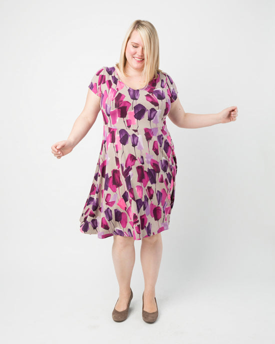 Woman wearing a floral dress on a white background. This dress is the Turner Dress sewing pattern from Cashmerette.