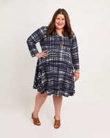 Woman wearing a blue plaid dress on a white background. This dress is the Turner Dress sewing pattern from Cashmerette.