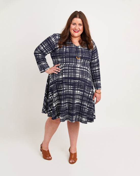Woman wearing a blue plaid dress on a white background. This dress is the Turner Dress sewing pattern from Cashmerette.