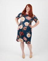 Woman wearing a floral dress on a white background. This dress is the Rivermont Dress & Top sewing pattern from Cashmerette.