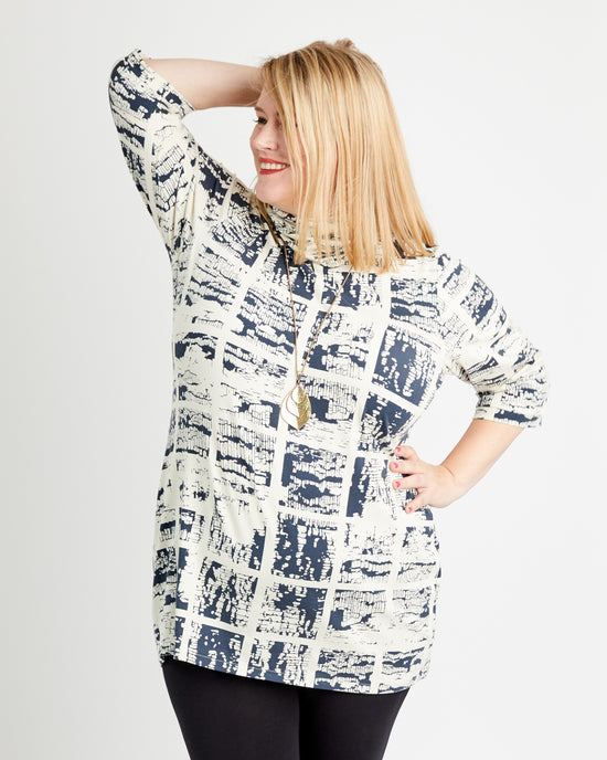 Woman wearing a patterned shirt with a plain background. This is the Pembroke Dress & Tunic sewing pattern from Cashmerette.