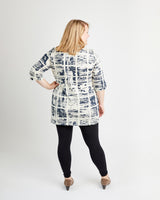 Woman wearing a patterned shirt and black leggings on a white background. This is the Pembroke Dress & Tunic sewing pattern from Cashmerette.