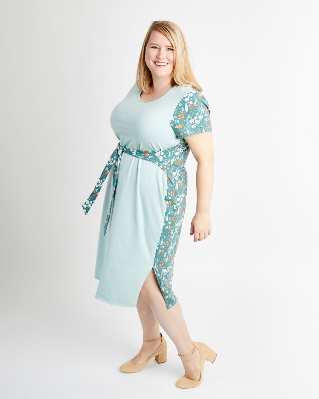 Woman wearing a light blue dress with floral sleeves on a white background. This is the Pembroke Dress & Tunic sewing pattern from Cashmerette.