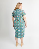 Woman wearing a teal floral dress on a white background. This is the Pembroke Dress & Tunic sewing pattern from Cashmerette.