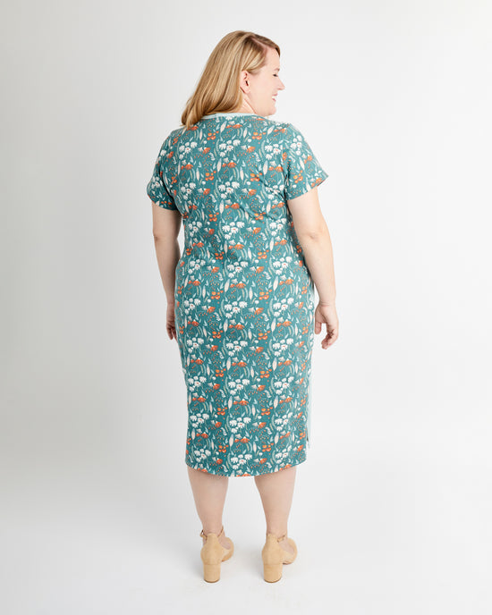 Woman wearing a teal floral dress on a white background. This is the Pembroke Dress & Tunic sewing pattern from Cashmerette.
