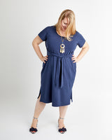 Woman wearing a blue dress with a white background. This is the Pembroke Dress & Tunic sewing pattern from Cashmerette.
