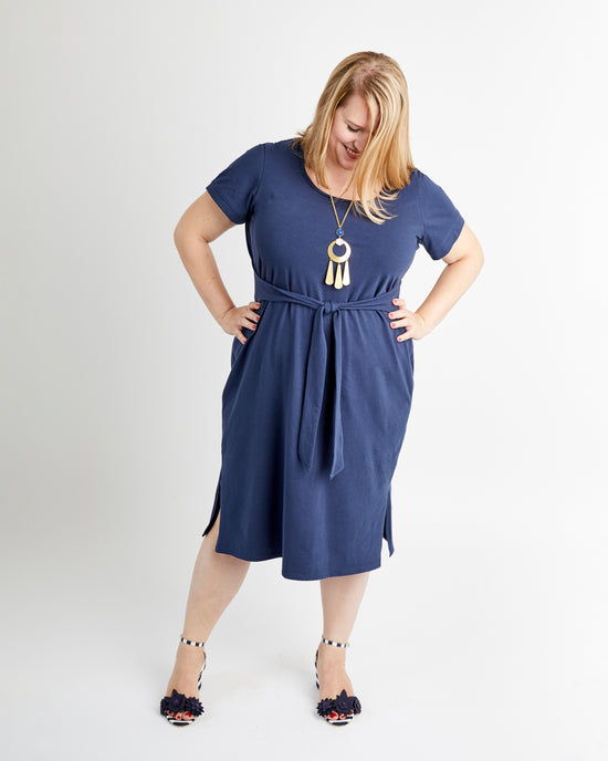 Woman wearing a blue dress with a white background. This is the Pembroke Dress & Tunic sewing pattern from Cashmerette.