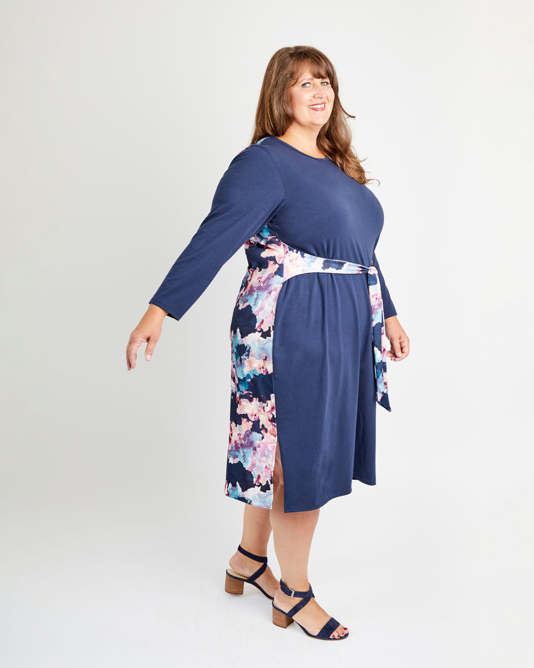 Woman wearing a blue dress with floral pattern on a white background. This is the Pembroke Dress & Tunic sewing pattern from Cashmerette.