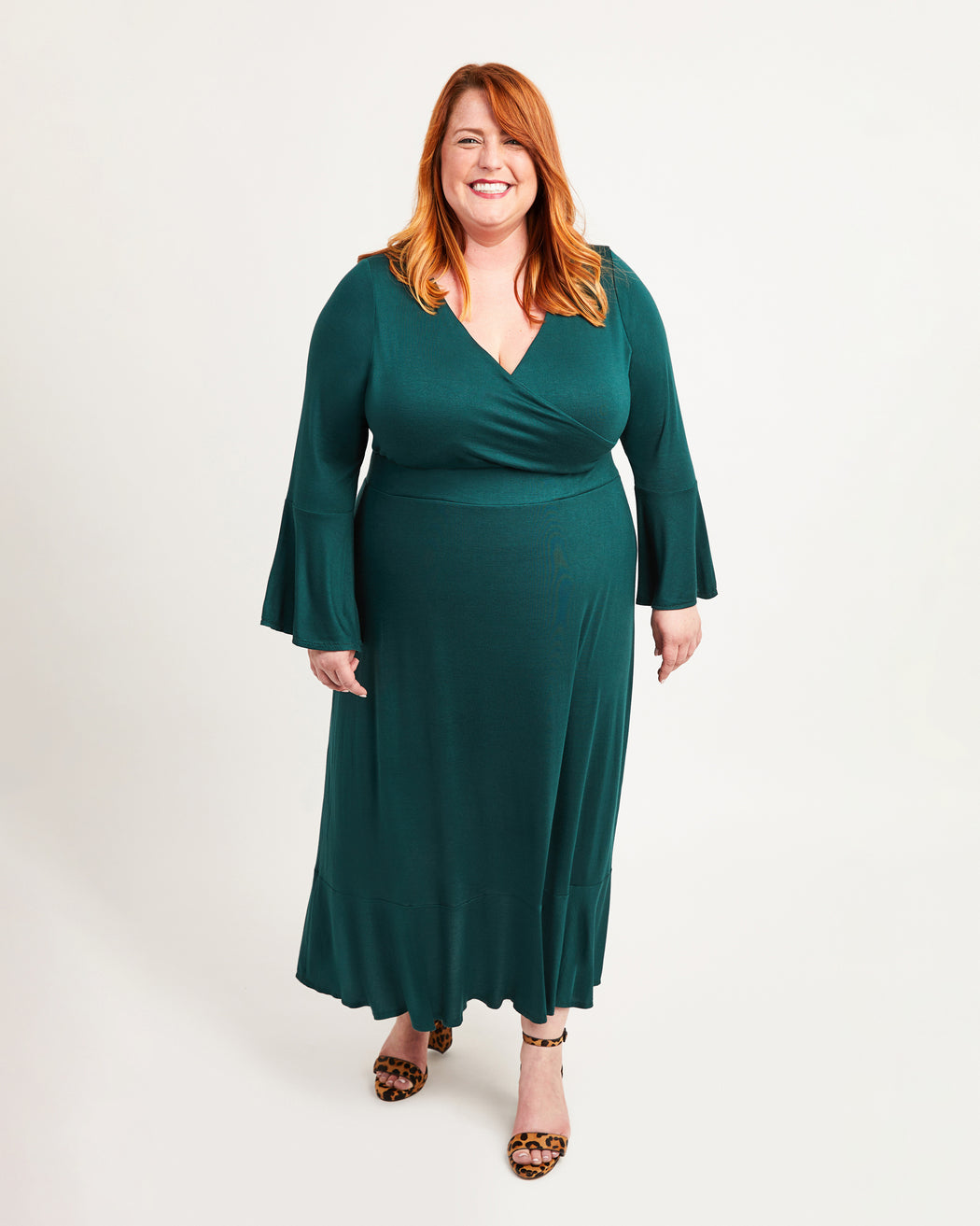 Woman wearing a green dress on a white background. This dress is the Alcott Dress sewing pattern from Cashmerette.