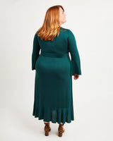 Woman wearing a green dress with long sleeves on a white background. This dress is the Alcott Dress sewing pattern from Cashmerette.