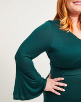Person wearing a green dress with bell sleeves against a plain background. This dress is the Alcott Dress sewing pattern from Cashmerette.