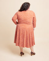 Woman wearing a patterned dress on a beige background. This is the Grafton Dress, Top & Skirt sewing pattern from Cashmerette.