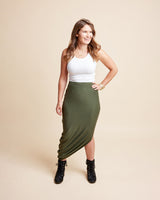Woman wearing a white top and green skirt on a beige background. This is the Grafton Dress, Top & Skirt sewing pattern from Cashmrette.