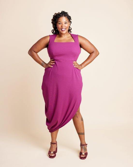 Woman wearing a magenta dress against a beige background. This is the Grafton Dress, Top & Skirt sewing pattern from Cashmerette.