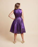 Woman wearing a purple dress against a beige background. This is the Grafton Dress, Top & Skirt sewing pattern from Cashmrette.