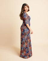 Woman wearing a floral dress on a beige background. This is the Grafton Dress, Top & Skirt sewing pattern from Cashmrette.