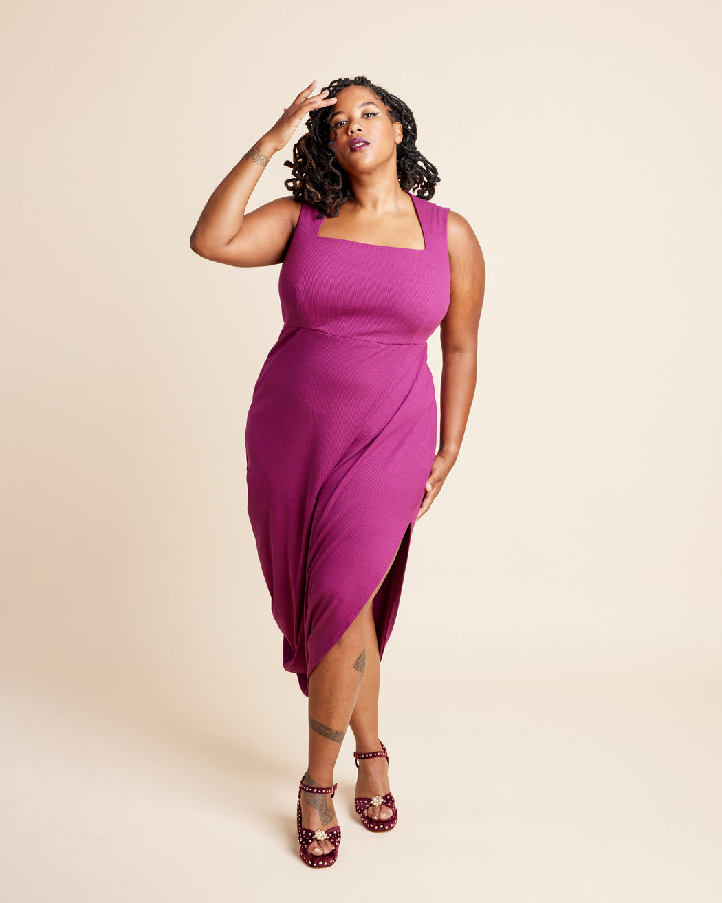 Woman wearing a magenta dress with a beige background. This is the Grafton Dress, Top & Skirt sewing pattern from Cashmerette.