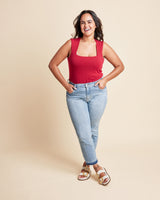 Woman wearing a red tank top and blue jeans against a beige background. This is the Grafton Dress, Top & Skirt sewing pattern from Cashmrette.