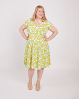 Woman wearing a yellow floral dress on a white background. This is the nursing expansion pack sewing pattern from Cashmerette.